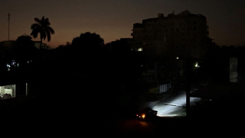 Car lights illuminate a street during a general blackout in Havana on March 14, 2025.