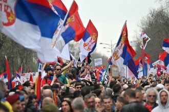 A protester holding the national flag rally during anti-corruption demonstrations in Belgrade on March 15, 2025.