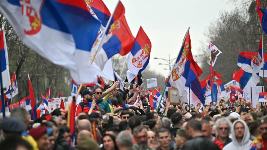 A protester holding the national flag rally during anti-corruption demonstrations in Belgrade on March 15, 2025.