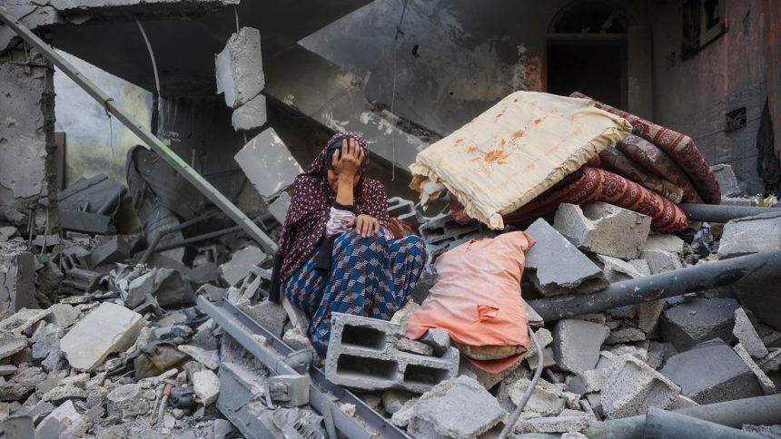 A Palestinian woman sits on the rubble of her house, destroyed in an Israeli strike, in the Nuseirat refugee camp in central Gaza on Tuesday.