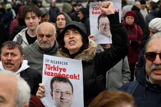 Supporters of Istanbul Mayor Ekrem Imamoglu hold a poster of him reading "CHP will make it, Turkey will win" as they demonstrate outside the city townhall, in Istanbul, Turkey on Wednesday.