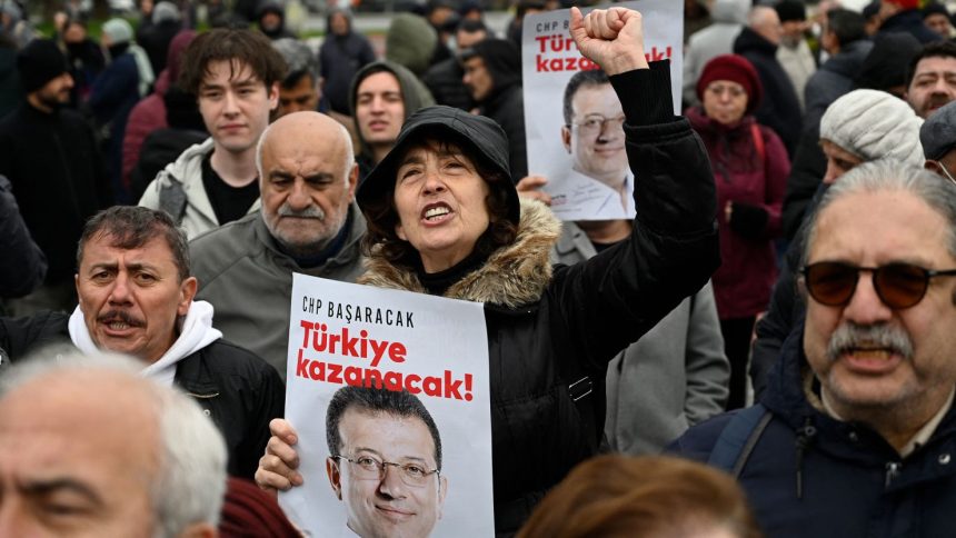 Supporters of Istanbul Mayor Ekrem Imamoglu hold a poster of him reading "CHP will make it, Turkey will win" as they demonstrate outside the city townhall, in Istanbul, Turkey on Wednesday.