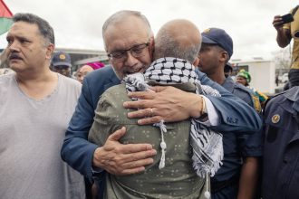 Former South African Ambassador to the United States, Ebrahim Rasool, greets relatives and supporters upon his arrival at Cape Town International Airport on March 23, 2025.