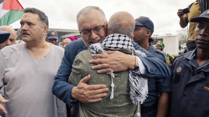 Former South African Ambassador to the United States, Ebrahim Rasool, greets relatives and supporters upon his arrival at Cape Town International Airport on March 23, 2025.