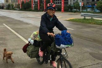 Li Dongju was accompanied by her brown poodle on her cycling journey across China in 2015.