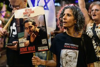 Vicky Cohen, mother of Israeli hostage Nimrod Cohen holds a placard with Nimrod's photo during a demonstration in Tel Aviv on Oct 12, 2024.