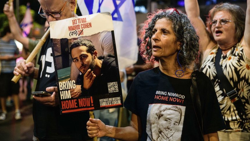 Vicky Cohen, mother of Israeli hostage Nimrod Cohen holds a placard with Nimrod's photo during a demonstration in Tel Aviv on Oct 12, 2024.