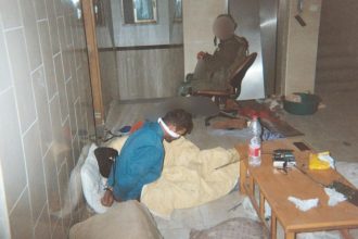 A photo shared by Breaking the Silence, an organization that provides a forum for Israeli soldiers to speak out and verifies their testimony, shows a soldier guarding a Palestinian prisoner, hands bound. Image blurred at source.