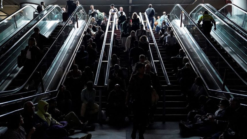 People wait on the stairs at Atocha train station in Madrid, during a massive power outage that left Spain and Portugal in the dark for hours.