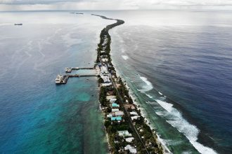 An aerial view of a strip of land between the Pacific Ocean (R) and lagoon on November 25, 2019 in Funafuti, Tuvalu.