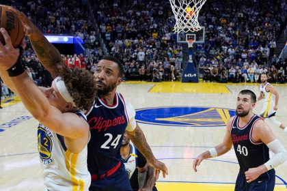 Golden State Warriors guard Brandin Podziemski (2) and Los Angeles Clippers guard Norman Powell (24) compete for a rebound during overtime on Sunday.