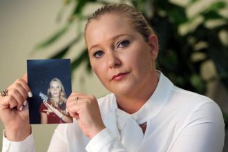 Virginia Giuffre holds a photo of herself as a teen.