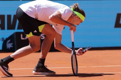 Alex Zverev takes a picture of the ball mark with his phone.