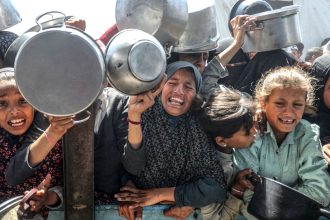 Displaced Palestinians receive hot meals distributed by aid organizations in al-Mawasi area of Khan Younis, Gaza on Tuesday.