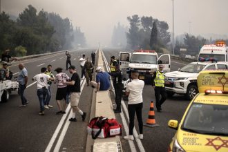 Security forces take precautions and close roads in response to a wildfire that broke out in a forested area between Tel Aviv and Jerusalem on Wednesday.