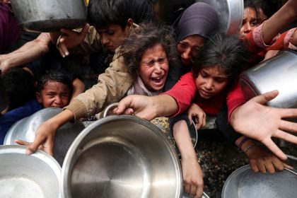 Palestinians wait to receive food cooked by a charity kitchen, in Jabalya, northern Gaza, on Wednesday.
