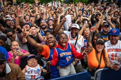 Tyler McCoy and his son Isaiah cheer for the New York Knicks at the watch party for Game 4 of round 2 of the NBA playoffs between the New York Knicks and Boston Celtics outside of Madison Square Garden on May 12.