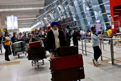 Travelers push luggage carts through New Delhi's Indira Gandhi International Airport.