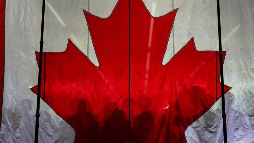 Supporters cast shadows on a Canadian flag as they gather prior to an election campaign event for Conservative Party of Canada's leader Pierre Poilievre, in Vaughan, Ontario, Canada April 22, 2025.