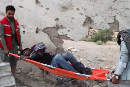 Rescuers carry an injured African migrant after a strike hit a detention centre hosting African migrants, in Saada, Yemen, on April 28, 2025.