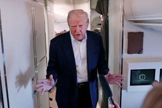 President Donald Trump speaks to members of the media aboard Air Force One.
