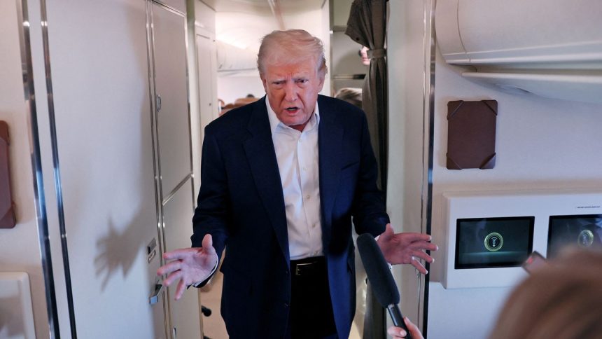 President Donald Trump speaks to members of the media aboard Air Force One.