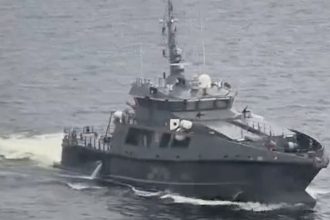 An Estonian military vessel sails near a Russian-bound oil tanker at sea, Gulf of Finland, in this screengrab taken from social media, May 13, 2025.