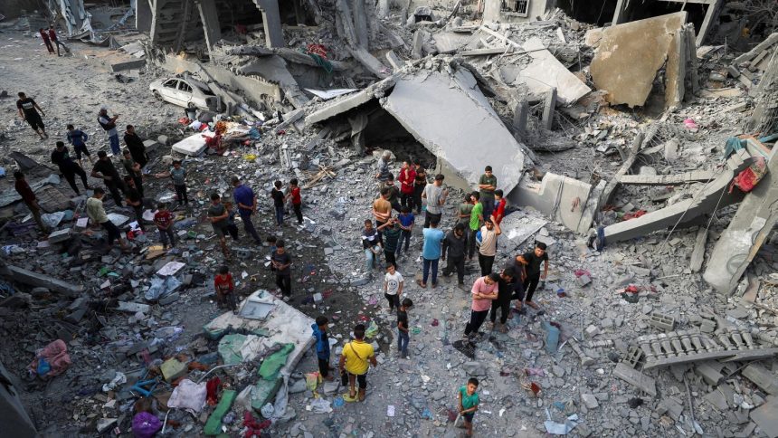 Palestinians inspect the site of an Israeli strike in Jabalya, northern Gaza on May 18, 2025.