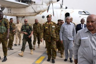 Sudan's military leader, General Abdel Fattah al-Burhan, center, arrives with officials and guards in the military airport of Port Sudan on August 27, 2023.