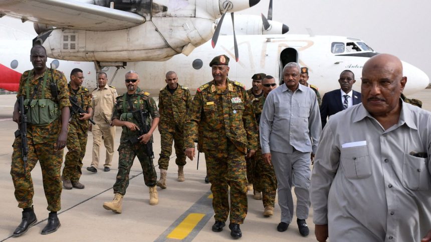 Sudan's military leader, General Abdel Fattah al-Burhan, center, arrives with officials and guards in the military airport of Port Sudan on August 27, 2023.
