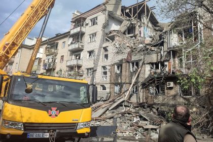 Emergency workers survey an apartment building hit by a Russian drone strike in Mykolaiv, Ukraine on May 25, 2025.