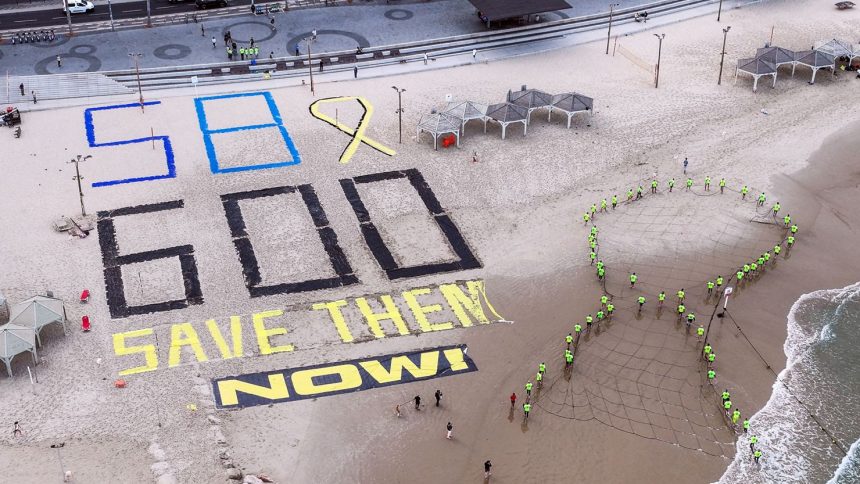 Israeli protesters display the words "SAVE THEM NOW", the number 600 for the number of days since hostages were kidnapped from Israel by Hamas, and the number 58 for the number of hostages still in Gaza, at the shore of the Mediterranean, opposite the US Consulate in Tel Aviv, Israel, on Wednesday.