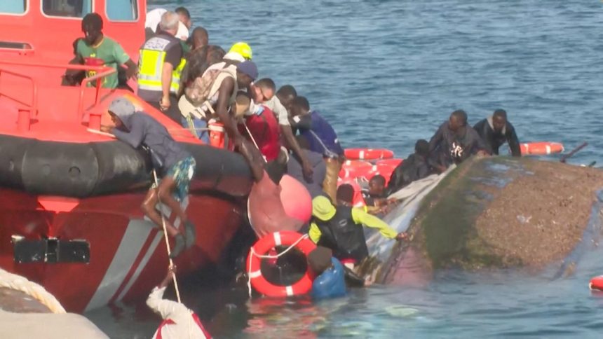 Emergency workers try to rescue migrants from the water after their boat capsized as rescuers were escorting it to port in Spain's Canary Islands on May 28, 2025.