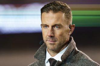 Former NFL quarterback Alex Smith looks on during an NFL game in 2022.