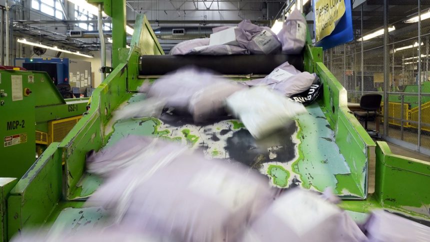 Parcels slide down a ramp after being scanned at the US Customs and Border Protection overseas mail inspection facility at Chicago's O'Hare International Airport in February 2024.