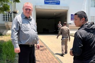American political science lecturer Paul Chambers stands outside the police station in Phitsanulok, Thailand, where he was arrested on charges of insulting the monarchy.