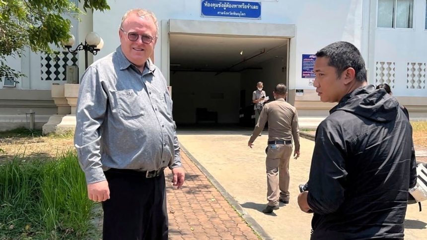 American political science lecturer Paul Chambers stands outside the police station in Phitsanulok, Thailand, where he was arrested on charges of insulting the monarchy.