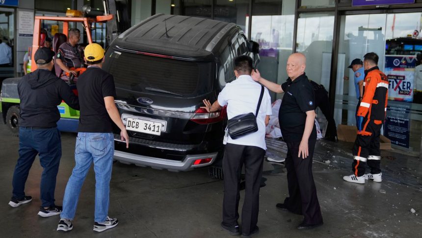 Airport authorities help first responders after a driver crashed an SUV into the entrance at Manila's International Airport Terminal 1 in Manila, Philippines, on Sunday, May 4, 2025.