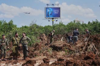 Israeli security forces inspect the site where a projectile fired by Yemen's Houthi rebels landed, near Ben Gurion Airport on Sunday.