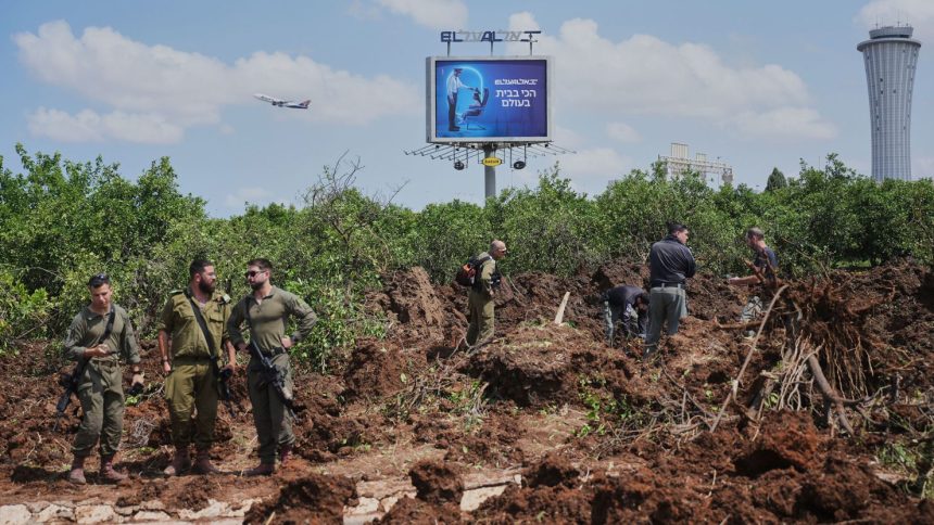 Israeli security forces inspect the site where a projectile fired by Yemen's Houthi rebels landed, near Ben Gurion Airport on Sunday.