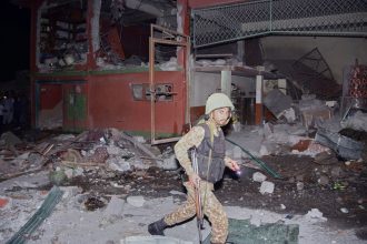 A soldier examines a building damaged by an Indian missile strike near Muzaffarabad in Pakistan-administered Kashmir on May 7, 2025.