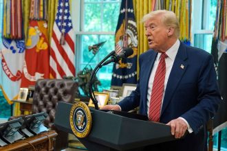 President Donald Trump speaks to reporters in the Oval Office.