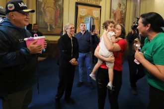 Venezuelan first lady Cilia Flores, second from left, and Interior Minister Diosdado Cabello, left, watch as 2-year-old Maikelys Espinoza is reunited with her mother Yorely Bernal at Miraflores presidential palace in Caracas, Venezuela, on Wednesday.