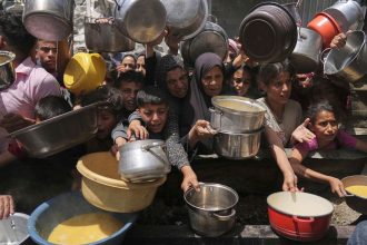 Palestinians struggle to get donated food at a community kitchen in Jabalia, northern Gaza Strip, on Monday, May 19, 2025.