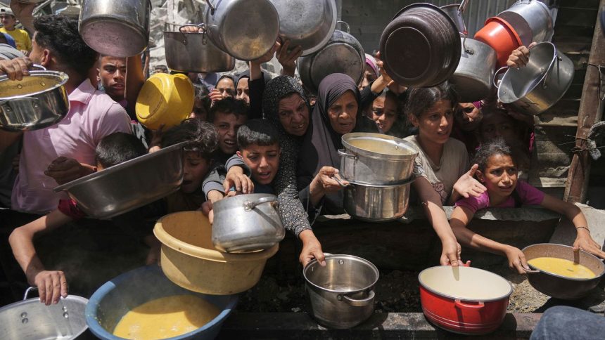 Palestinians struggle to get donated food at a community kitchen in Jabalia, northern Gaza Strip, on Monday, May 19, 2025.