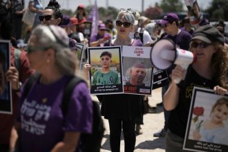 People hold pictures of hostages held by Hamas and children killed by Israeli bombardment in the Gaza Strip at a protest near the Israeli-Gaza border in Sderot, southern Israel, Friday, May 23, 2025.
