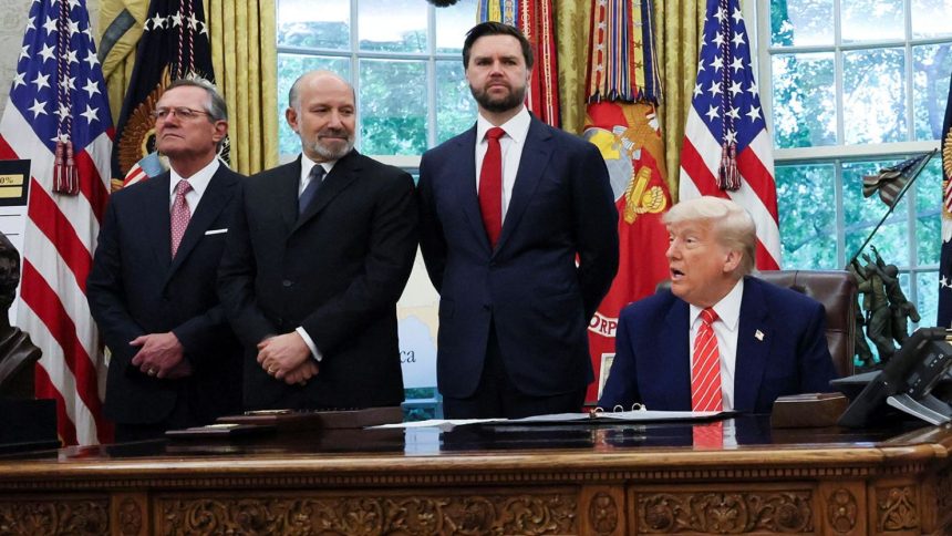 President Donald Trump is flanked by aides as he makes an announcement about a trade deal with the UK in the Oval Office at the White House in Washington, DC, on May 8.