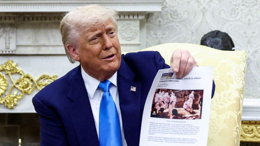 President Donald Trump shows a copy of an article in the Oval Office of the White House in Washington, DC, on May 21.