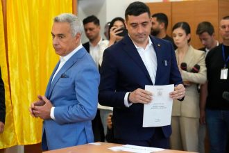 Presidential candidate George Simion, right, casts his vote next to Calin Georgescu, winner of the first round of last year's annulled election, during the first round of the presidential election redo in Bucharest, Romania, on May 4.
