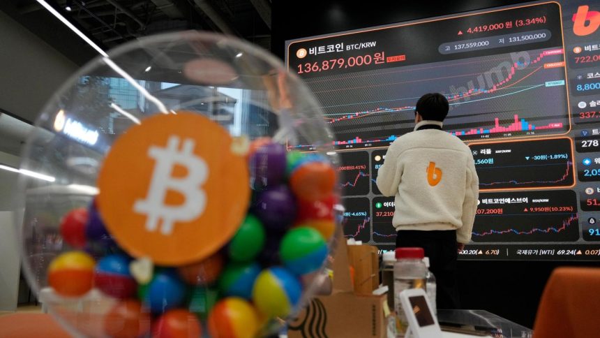 An employee watches an electronic signboard displaying the prices of Bitcoin and other cryptocurrencies at the lounge of Bithumb cryptocurrency exchange in Seoul, South Korea, in November.